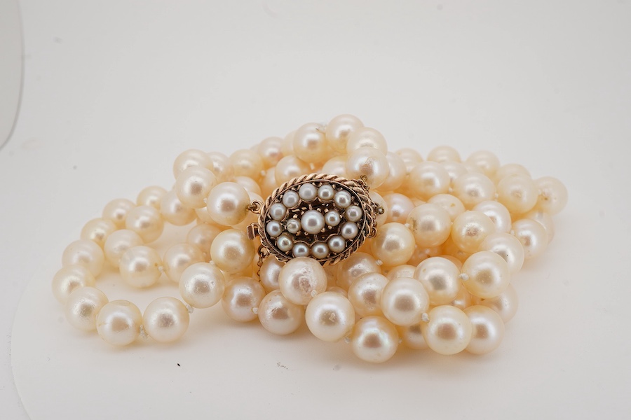 A double strand cultured pearl necklace, with a 9ct gold and cultured pearl cluster set clasp, pearl diameter approximate range 8.4mm-9mm.